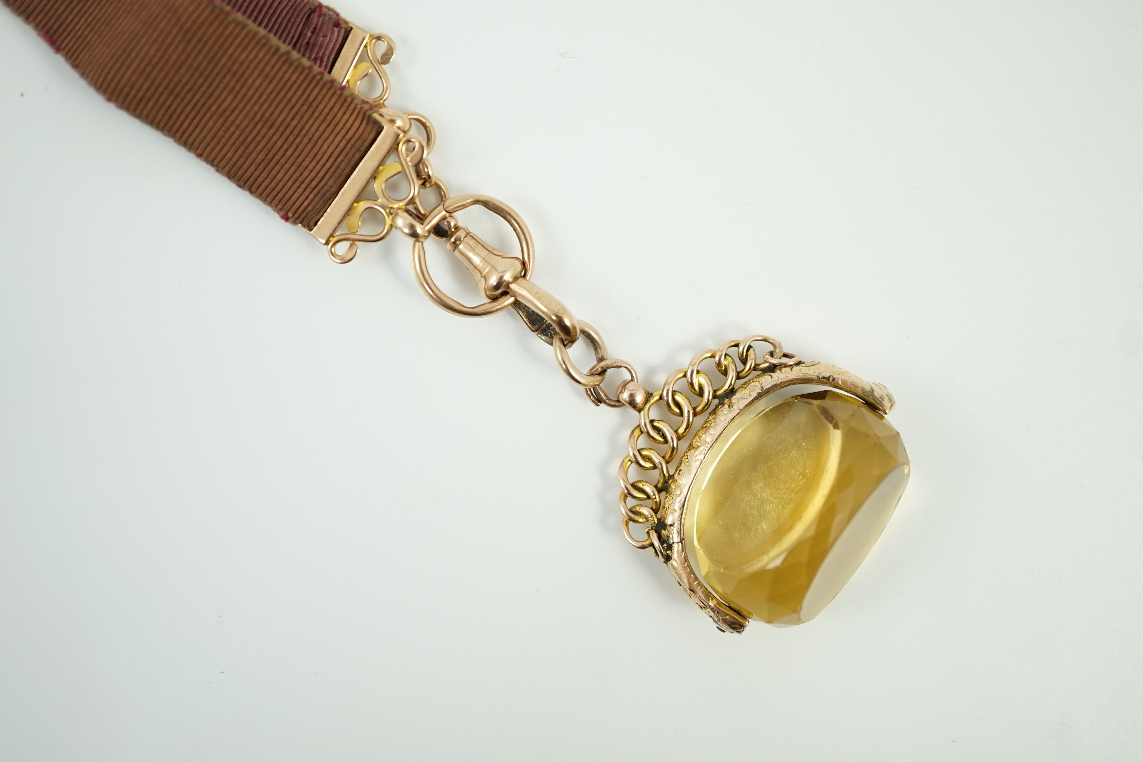 A late Victorian yellow metal and citrine set spinning fob, width 37mm, on a yellow metal mounted suspension sash, gross weight 31.6 grams.